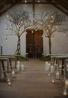 the inside of a church with candles lit up in front of it and trees on either side