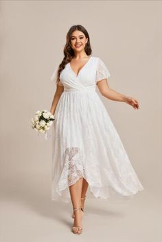 a woman wearing a white dress and holding a bouquet