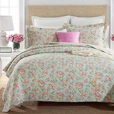 a bed with pink and green flowers on it