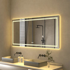 a bathroom with two sinks and a large lighted mirror above the sink is lit up