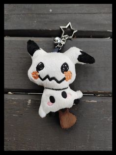 a stuffed animal keychain with a star on it's head and eyes