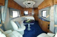 the inside of a motor home with couches and tables in it's living room