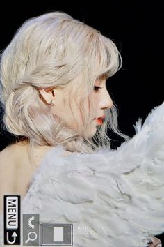 a close up of a person with white hair and an angel wings on their back