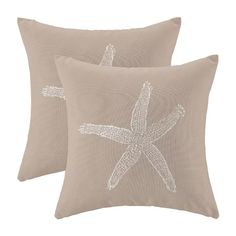 two beige pillows with white starfishs on them