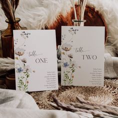 two cards with flowers are sitting on a table