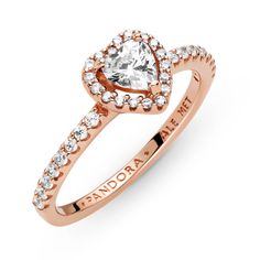 Add a sophisticated edge to your look with the Sparkling Elevated Heart Ring. The ring draws inspiration from the classic Pandora Timeless collection. Hand-finished in 14K rose gold-plating, this piece features a clear heart-shaped central, elevated cubic zirconia. Clear cubic zirconia create the halo and decorate half of the ring band, with the Pandora logo on the inside of the shank. Stack this ring with hand-finished styles in sterling silver for a statement mixed metal look. Elevated Heart Ring, Pandora Logo, Pandora Jewelry Charms, Pandora Rose, Beautiful Hairstyle, Timeless Ring, Bracelet Pandora, Diamond Heart Ring, Pandora Rings