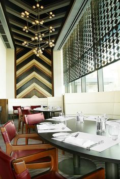 a long table with red chairs in a restaurant