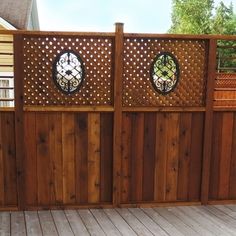 a wooden fence with two circular stained glass windows on the top and bottom paneling