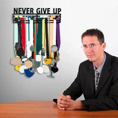 a man sitting at a table in front of a wall with medals hanging on it