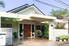 a small white house with plants on the front