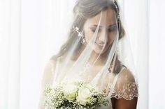 a woman wearing a veil holding a bouquet of flowers