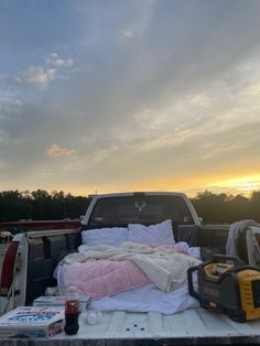 a truck bed with blankets and other items in the back