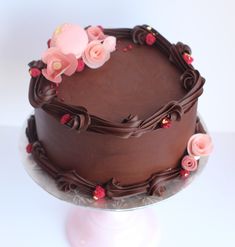 a chocolate cake with pink flowers on top