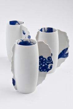 three blue and white vases sitting next to each other