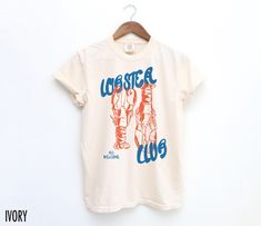 Embrace coastal charm with this vintage-inspired tee! Featuring a hand-drawn lobster graphic and the phrase "Lobster Club, All Welcome," this shirt brings a touch of retro style to your everyday look. We use professional quality DGT printing on all our apparel. Direct-to-garment, or DTG, is a high quality printing method that sprays ink directly onto the garment so there is no peeling or cracking. This fabulous graphic will be printed on a Comfort Colors Unisex T-Shirt. Please refer to the size Food Graphic Tee, Lobster Graphic, Lobster Shirt, Aesthetic Coastal, Vintage Diner, Food Shirt, Coastal Charm, Aesthetic T Shirts, Retro Summer