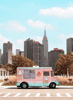 a pink ice cream truck parked in front of a cityscape with tall buildings