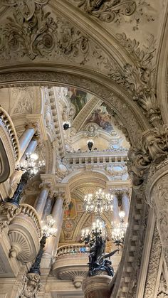 an ornate building with chandeliers and statues in the center is seen from below