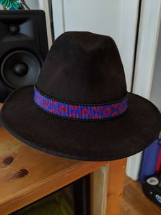 This hat band is made to order and will take approximately 1-3 weeks to create (please message me if you need an exact time frame). All hat bands are created on a loom and handwoven by me. Hat bands are finished with faux leather, deerskin ties, and pewter beads. Approximate width is 1 inch. When checking out, please provide the measurement of your hat so I can ensure appropriate fit.  Colors may be interchanged, and custom requests are welcome. Due to the handmade nature of the process, individ Adjustable Brimmed Hats With Bead Caps, Traditional Handmade Wide Brim Fedora, Handmade Fedora With Flat Crown For Festivals, Adjustable Festival Hats With Bead Caps, Traditional Adjustable Hats With Bead Caps, Festival Adjustable Hats With Bead Caps, Adjustable Bead Caps Hats For Festivals, Handmade Curved Brim Hat Band For Country Events, Handmade Flat Crown Fedora For Festivals