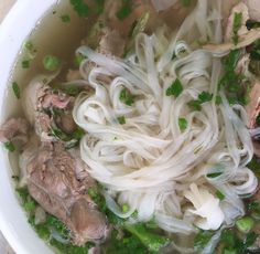 a white bowl filled with noodles and meat