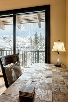 a wooden table sitting in front of a sliding glass door