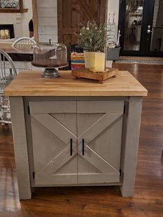 a kitchen island with a cutting board on top of it in the middle of a room