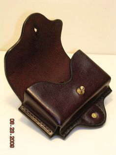 a brown leather wallet sitting on top of a white table