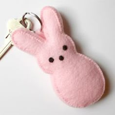 a pink bunny keychain with black eyes on it's face and ears