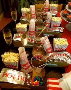 an assortment of snacks and drinks on a table at a movie themed party with popcorn