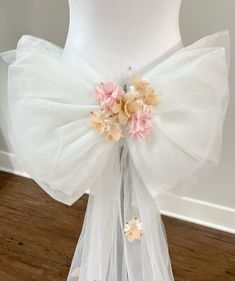 a white dress with pink flowers on the front and back, attached to a mannequin