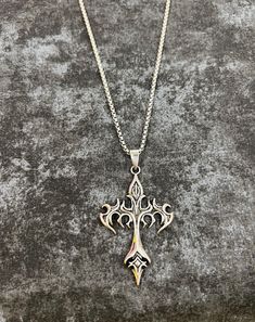 Ignite your style with our Flame Cross Gothic necklace, a captivating blend of dark allure and fiery elegance. This eye-catching piece features a striking silver chain that holds a bold cross pendant, intricately detailed with flame motifs that evoke both intensity and passion. The pendant's dark, burnished finish is contrasted by the gleaming silver highlights, creating a dramatic effect that catches the eye from every angle. Designed for those who embrace gothic sophistication with a touch of Necklace Grunge, Cross Gothic, Grunge Necklace, Goth Necklace, Silver Highlights, Necklace Stand, Gothic Necklace, Handcrafted Necklace, Cross Pendant Necklace