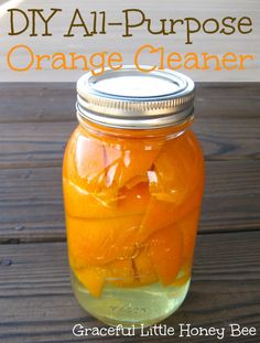 a jar filled with oranges sitting on top of a wooden table