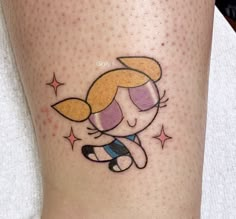 a cartoon character tattoo on the leg of a woman's leg, with stars around her