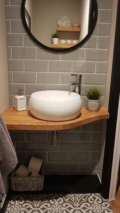 a bathroom sink sitting under a round mirror