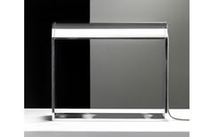 an illuminated table lamp sitting on top of a white counter next to a black wall