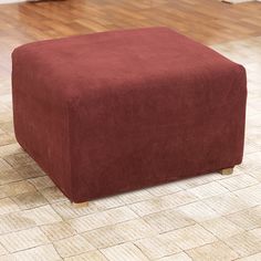 a red foot stool sitting on top of a hard wood floor