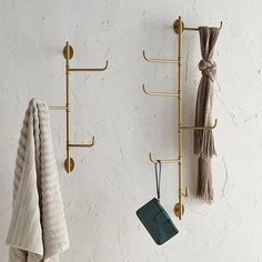 two towel racks are hanging on the wall next to each other, with hooks holding towels