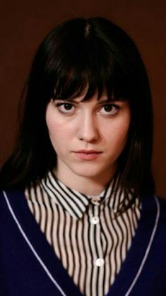 a woman with black hair wearing a striped shirt