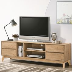 a flat screen tv sitting on top of a wooden entertainment center in a living room