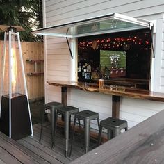 an outdoor bar with stools and lights