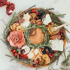 a platter filled with cheese, meats and vegetables on top of a table