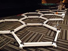 several white pipes are laying on the floor in front of each other, forming a hexagonal pattern