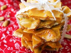 a pile of food sitting on top of a red and white table cloth next to nuts