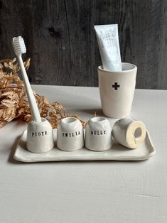 three toothbrushes and two cups on a tray