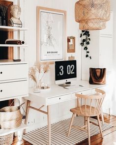 a desk with a computer on top of it next to a chair and potted plant