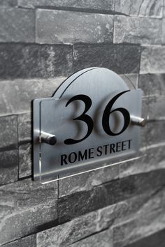 a sign that is on the side of a stone wall reading'360 rome street '