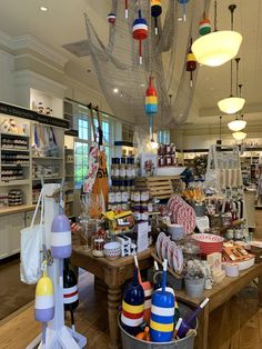 the inside of a store with lots of items on display and lights hanging from the ceiling