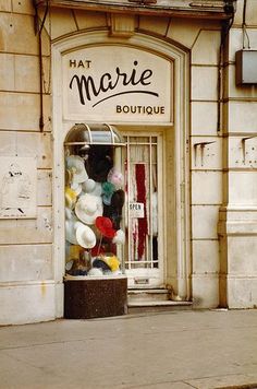 an old fashion store front with lots of balloons in the window