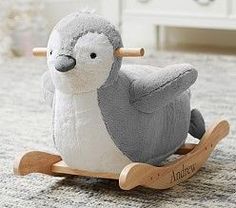 a stuffed bird sitting on top of a wooden rocking toy