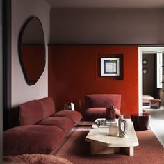 a living room with red walls and furniture