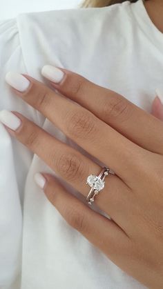 a woman's hand with a ring on it and a diamond in the middle